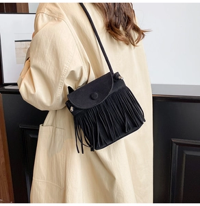 Detail einer schwarzen Wildleder-Fransentasche mit Boho-Fransen an einem weiblichen Model