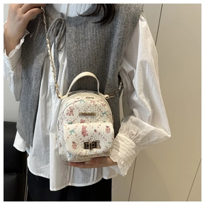 Detail of white mini backpack with floral bunny print and golden fashion logo buckle