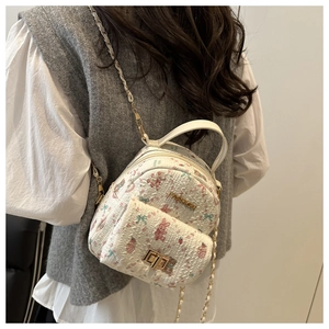 Detailed back view of a white mini backpack with pink rabbit prints and chain strap