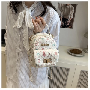 Close-up of mini white floral backpack with cute rabbit prints and gold clasp