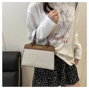 Canvas and brown leather patchwork tote bag styled by model for a casual commute look
