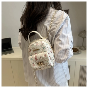 Detail showing white quilted mini backpack with cute pink rabbit floral prints and chain