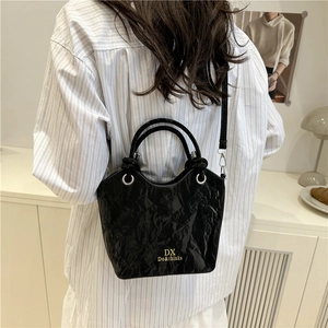 Chic black pleated leather bucket bag for women with gold logo and crossbody strap