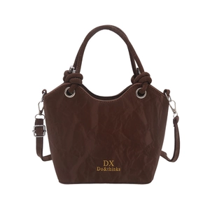 Minimalist brown pleated bucket bag with knot handles and adjustable shoulder strap