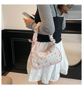 Detail of white quilted handbag with cute pink bear print and ruffled shoulder strap