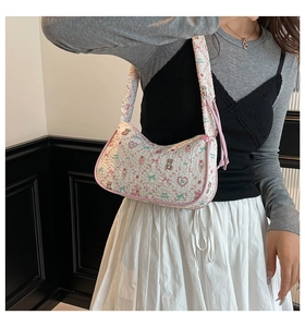 Quilted crossbody bag with cute teddy bear prints and pink piping shown on shoulder