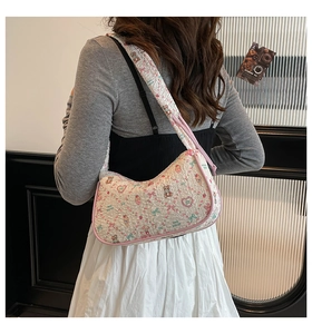 Detail of a floral bear print pleated shoulder bag with pink trim and texture