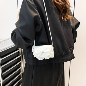 Chic cream mini crossbody bag with a large lace bow and elegant leather strap for women