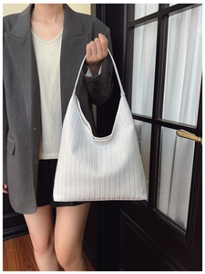 Détail de la texture tissée blanche avec motif à chevrons en V sur un grand sac hobo