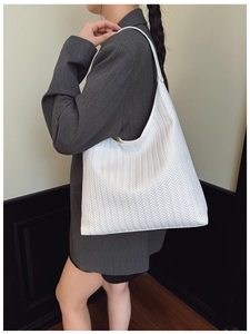 Gros plan détaillé de la texture tissée blanche d'un grand sac cabas minimaliste pour femme