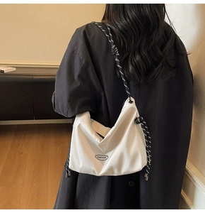 Detail der weißen Nylon-Hobo-Tasche mit schwarz-weiß geflochtenem Seilschultergurt