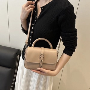 Fashionable beige soft leather shoulder bag with gold horseshoe buckle and adjustable strap