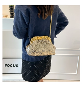 Dettaglio di una pochette a nuvola con paillettes dorate e tracolla a catena sottile