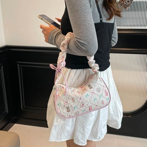 Quilted white shoulder bag with cartoon bear prints and ruffled handle on female model