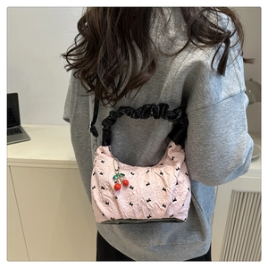 Dettaglio della borsa plissettata rosa con stampe di conigli neri e ciondolo a ciliegia