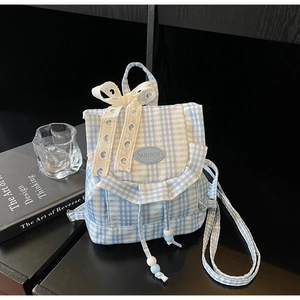 Close-up of blue plaid mini backpack featuring lace heart bow and ruffle details