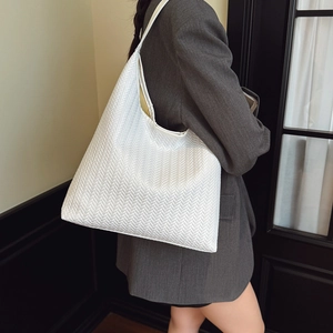 Sac fourre-tout blanc chic à texture tissée présenté dans un style de vie minimaliste