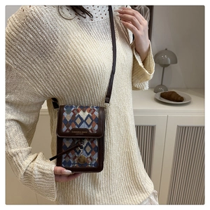 Detail of vintage crossbody phone bag featuring multicolor knit pattern and leather trim