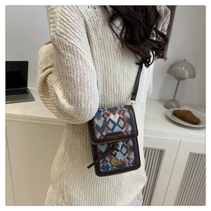 Chic retro crossbody bag with geometric pattern shown on model in cozy interior