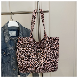 Detail of pink leopard print canvas tote bag hanging next to a denim jacket