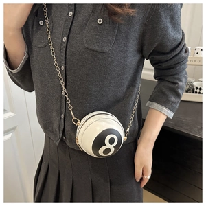 Close-up of a white billiard 8-ball shaped mini crossbody bag with a gold chain strap