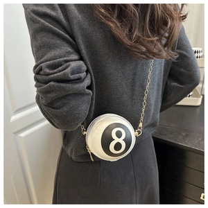 Detailed view of billiard number 8 round crossbody bag with golden chain on model