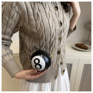 Detail of creative black billiard number 8 round bag with golden metal chain strap