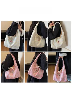 Detail view of plaid canvas tote bag with cherry patch and decorative beige ribbons