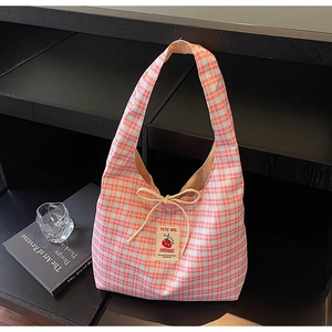 Detail of pink plaid canvas tote bag with yellow bow and handmade brand label