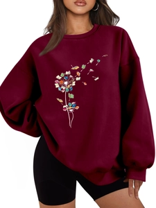 Close-up of dandelion and flying books print on wine red oversized cotton sweatshirt