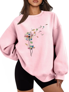 Close-up of artistic dandelion books print on pink oversized crewneck sweatshirt