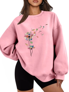 Close-up of pink oversized sweatshirt showing dandelion book print and ribbed neckline