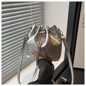 Detail of silver metallic bucket bag with chain drawstring and leather shoulder strap