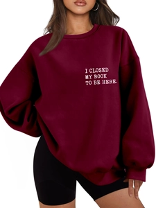 Detail of white printed text on thick burgundy crewneck sweatshirt with ribbed cuffs
