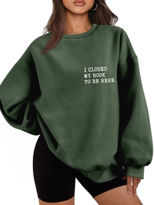 Detail of white I CLOSED MY BOOK printed text on casual thick dark green sweatshirt