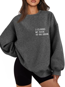 Close-up of white text print on thick charcoal grey crewneck sweatshirt fabric