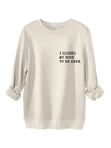 Detail of chest print on cream sweatshirt showing the text I closed my book to be here