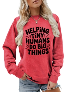 Detail of red crewneck sweatshirt with 'HELPING TINY HUMANS' slogan and heart graphics