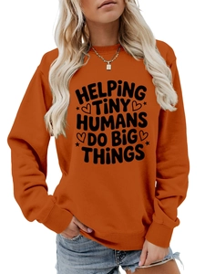 Close-up of ribbed cuffs and slogan print on orange crewneck sweatshirt