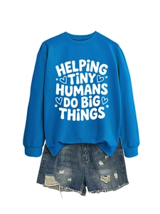 Blue crewneck sweatshirt with 'Helping Tiny Humans' text paired with denim shorts