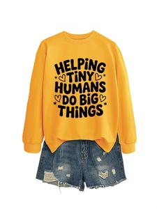 Detail of mustard yellow sweatshirt with inspirational text and ripped denim shorts set