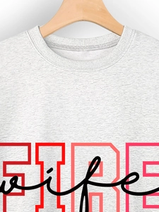 Close-up of ribbed crewneck and gradient FIRE wife printed lettering on gray sweatshirt
