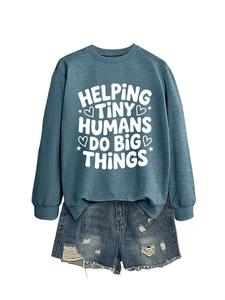 Detail of teal sweatshirt featuring white text print and distressed denim shorts