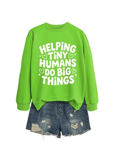 Flat lay of green crewneck sweatshirt with slogan and distressed denim shorts outfit
