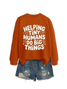 Detailed flat lay of burnt orange sweatshirt with slogan and distressed denim shorts