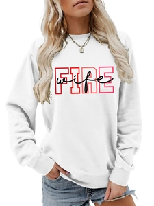 Close-up of white crewneck sweatshirt featuring pink FIRE and black wife slogan print