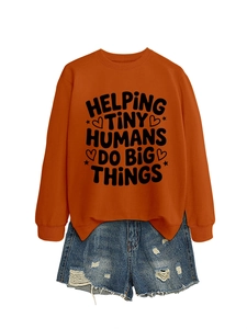 Detail of orange sweatshirt with Helping Tiny Humans print and ripped denim shorts