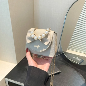 Mini beige girls pearl handle crossbody bag with bow and dog logo on textured leather