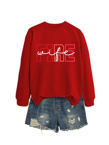 Detail of red crewneck sweatshirt with Fire Wife print paired with ripped denim shorts