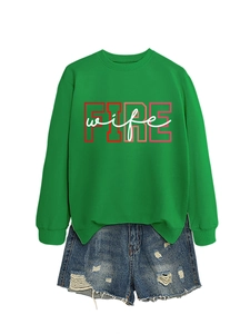 Flat lay of green sweatshirt with FIRE wife print and distressed blue denim shorts